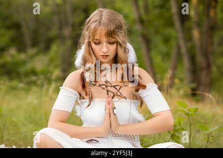 Porträt junger Schamaninnen, die im Wald meditieren Stockfoto