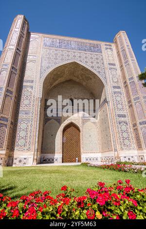 Blick auf das Portal der Bibi Khanum Moschee, mit Garten und Blumen im Vordergrund Stockfoto