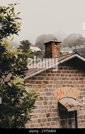 Die zeitlose Eleganz der rustikalen Architektur, umgeben von einer ruhigen, nebeligen Landschaft. Stockfoto