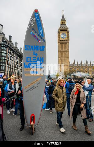 London, Großbritannien. November 2024. Ein Surfer sagt: „Steh Up for Clean Water“ - der Marsch für sauberes Wasser erreicht den Parliament Square - Extinction Rebellion tritt einer Koalition von River Action, Greenpeace & Surfers gegen Abwasser und führenden Persönlichkeiten wie Chris Packham bei einem friedlichen Protest bei, der sauberes Wasser und echte Rechenschaftspflicht fordert. Sie weisen darauf hin, dass "Großbritannien das einzige Land der Welt mit einem vollständig privatisierten Wassersystem ist, wir jedoch mit 1.000 illegalen Abwasserdeponien konfrontiert sind und dass Unternehmen 78 Milliarden Pfund an Gewinnen gemacht haben". Guy Bell/Alamy Live News Stockfoto