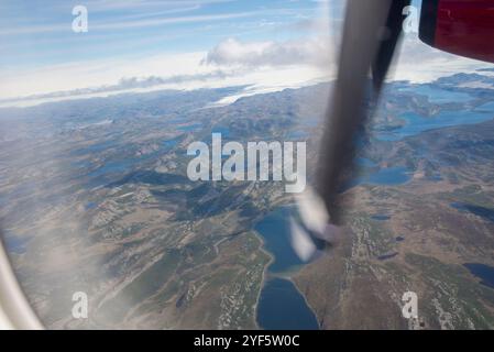 Dieses atemberaubende Bild fängt die atemberaubende grönländische Landschaft von einem Flugzeugfenster aus ein. Die weite Weite zeigt die Landschaft Stockfoto