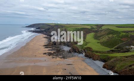 Blick aus der Vogelperspektive auf Sandymouth Beach mit den GCHQ Bude Satellitenschüsseln im Norden. Stockfoto