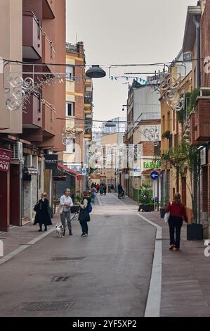 Viladecans. Spanien - 03. November 2024: Fußgängerzone in Viladecans mit dekorativen Lichtern und Spaziergängen, umgeben von Wohnhäusern Stockfoto