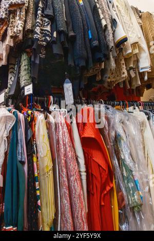 Vielfältige Sammlung von stilvollen Kleidern, Oberteilen und Kleidungsstücken in verschiedenen Mustern, die an Regalen hängen, Teil der zeitgenössischen Garderobe im Horse Hospital. Stockfoto