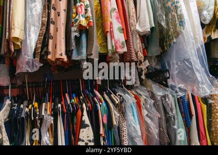 Vielfältige Sammlung von stilvollen Kleidern, Oberteilen und Kleidungsstücken in verschiedenen Mustern, die an Regalen hängen, Teil der zeitgenössischen Garderobe im Horse Hospital. Stockfoto