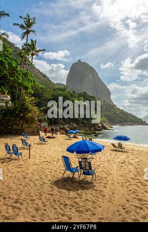 Sonnenliegen und Sonnenschirme im Praia Vermelha (Roter Strand) in Rio de Janeiro Stockfoto