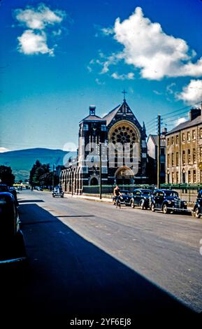 Die Dominikanerkirche in Castleisland, County Kerry, Irland, 1957 mit Autos aus dieser Zeit, die auf der Straße geparkt wurden. Stockfoto