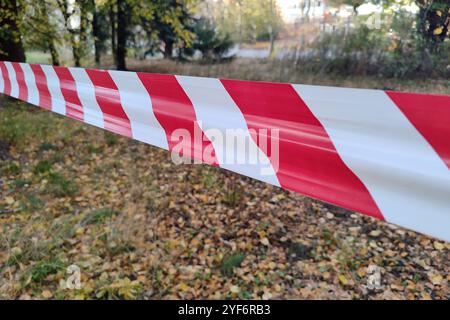 Rote und weiße Linien des Zaunbandes. Das rote und weiße Band, das die Bewegung verbietet, umzäunt. Warnband. Stockfoto