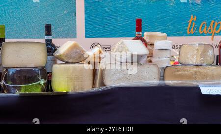 Cremona, Italien - 3. November 2024 Auswahl an Käseröhren und Weinflaschen auf dem Tisch an einem Marktstand, bereit zum Verkauf Stockfoto