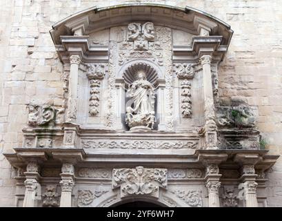 Ein wunderschön detailliertes Steinrelief, das eine religiöse Figur darstellt, eingerahmt von kunstvoller Architektur, zieht die Aufmerksamkeit auf sich. Stockfoto