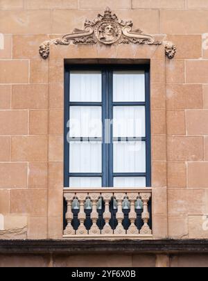 Ein wunderschön gearbeitetes Fenster mit verzierten Säulen und dekorativen Motiven zeigt die klassische Architektur eines Stadtgebäudes. Stockfoto