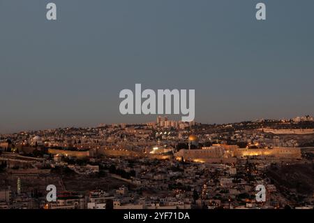 Panoramablick auf die alten Mauern der Altstadt von Jerusalem mit dem goldenen Felsendom, der in der blauen Stunde bei Dämmerung beleuchtet wird. Stockfoto