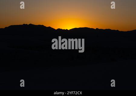 Hintergrundlicht Vom Orange Glow Of Sunset Hinter Der Silhouette Der Andres Mountains Im White Sands National Park Stockfoto