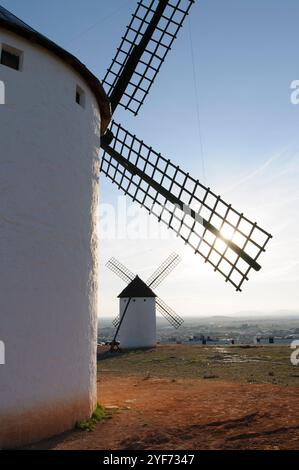 Campo de Criptana;Spanien;02152009: Auf einem Hügel befindet sich eine Windmühle mit zwei anderen Windmühlen im Hintergrund. Die Sonne scheint auf die Windmühlen und schafft einen Stockfoto