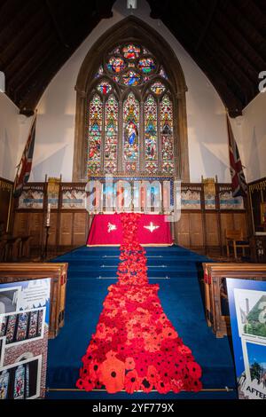 Ausstellung von gestricktem und gehäkeltem rotem Mohn in der Royal Garrison Church of All Saints for Remember Day, Hampshire, England, Großbritannien, November 2024 Stockfoto