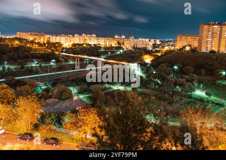 Nächtliche Luftaufnahme des Wohnviertels Areeiro in Lissabon, Portugal. Beleuchtete Stadtlandschaft mit Apartmentgebäuden, Straßenlaternen, Grünflächen und Stockfoto