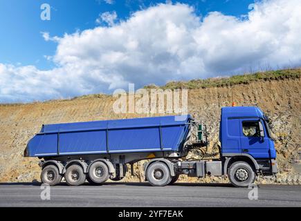 Straßenbau - blauer LKW steht bei Asphaltierungsarbeiten auf einer neuen Fahrbahn einer Autobahnauffahrt - Praxisfoto. LKW steht auf einer neuen breiten Strassemit einer Ladung heißem Asphalt bereit, um die Asphaltfertiger Anlage mit Asphalt zu versorgen. Praxisfoto. Raum Weser-Ems Niedersachsen Deutschland *** Straßenbau blauer Lkw steht auf einer neuen Fahrbahn einer Autobahnrampe während der Asphaltierung Praxisfoto-Lkw steht auf einer neuen breiten Straße mit einer Ladung heißem Asphalt bereit, das Asphaltfertigungswerk mit Asphaltpraxis zu versorgen Foto Weser Ems Gebiet Niedersachsen Deutschland Stockfoto