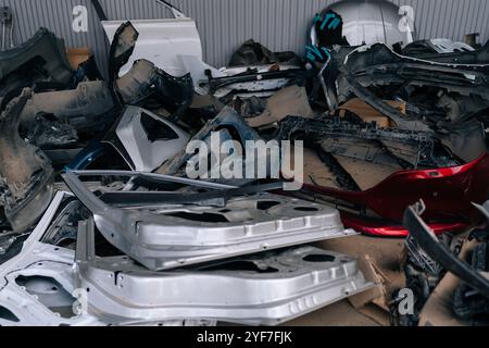 Nahaufnahme der zerstörten Autotüren, die beim Karosseriebaumechaniker gestapelt sind. Tauschen Sie gebrauchte Autoersatzteile ein. Viele benutzte weiße Türen von Autos auf Schrottplatz. Stockfoto