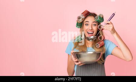 Hausfrau mit Schöpfkelle, Verkostung von Lebensmitteln aus großer Schüssel Stockfoto