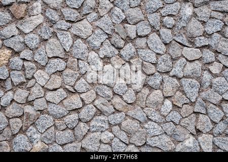 Grauer Pebbledash-Effekt im Stil der 1970er Jahre auf Einer Gebäudewand Stockfoto