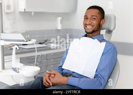 Glücklich schwarzen Kerl sitzt auf Zahnarztstuhl, die Zahnklinik Stockfoto