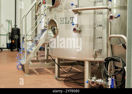 Industrielle Biertanks mit Schläuchen und Manometern in der Produktionsanlage Stockfoto