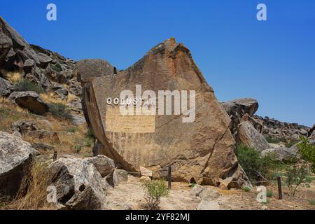 Gedenktafel auf einem riesigen Felsbrocken am Eingang zum staatlichen Historischen und Kulturreservat Gobustan in Gobustan, Aserbaidschan Stockfoto