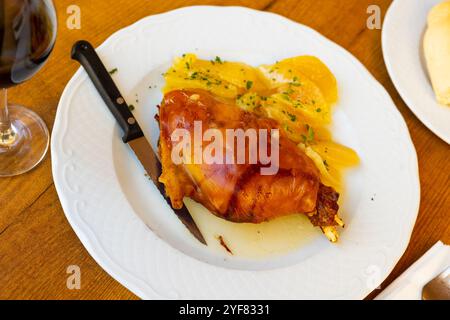 Gebratenes Spanferkel mit Kartoffeln auf dem Tisch Stockfoto