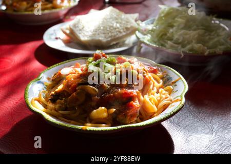 Pasta mit Meeresfrüchten eine Garnitur mit gehackten Frühlingszwiebeln, Hintergrundbeleuchtung, Beilagen, Brotbutter, Meeresfrüchten, dekorierter Teller, Norfolk, UK Stockfoto