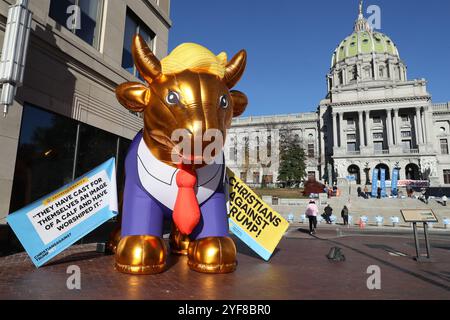 Harrisburg, Usa. November 2024. Ein aufblasbares goldenes Kalb, das als Donald Trump gekleidet ist, wird am Sonntag, den 3. November 2024 in der Nähe des Kapitols von Pennsylvania in Harrisburg ausgestellt. (Foto: Paul Weaver/SIPA USA) Credit: SIPA USA/Alamy Live News Stockfoto