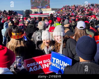 Lititz, Pennsylvania, USA. 3. November 2024. Zwei Menschen werden mit Trump-Schildern fotografiert, während Anhänger des ehemaligen US-Präsidenten Donald J. Trump an einer Kundgebung teilnehmen, bei der Trump nur zwei Tage vor dem Wahltag 2024 in Lititz, PA, sprach. Pennsylvania ist ein entscheidender Wendestaat bei den Wahlen. Autor: John Lazenby/Alamy Live News Stockfoto