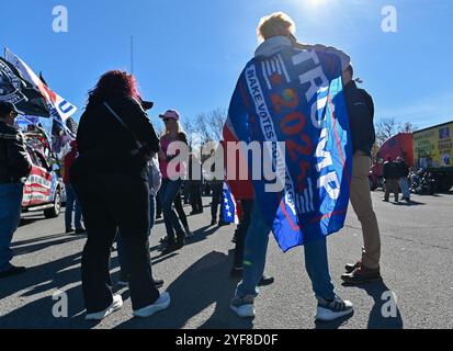 Edwardsville, Usa. November 2024. Ein Mann trägt eine Trump-Perücke und -Flagge. Luzerne County, ein normalerweise demokratisches County, hat die Wahl 2016 umgedreht. Das Pennsylvania County ist ein Hot Spot für diese Wahl. Trump-Anhänger führten eine Parade durch das County, um den ehemaligen Präsidenten zu unterstützen. Quelle: SOPA Images Limited/Alamy Live News Stockfoto