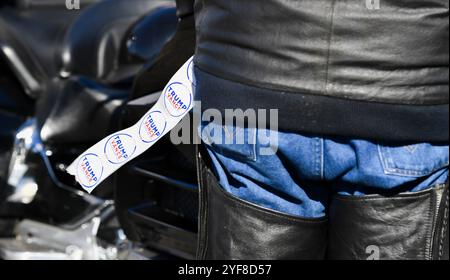 Edwardsville, Usa. November 2024. Ein Biker für Trump gibt Trump Vance Sticker aus. Luzerne County, ein normalerweise demokratisches County, hat die Wahl 2016 umgedreht. Das Pennsylvania County ist ein Hot Spot für diese Wahl. Trump-Anhänger führten eine Parade durch das County, um den ehemaligen Präsidenten zu unterstützen. (Foto: Aimee Dilger/SOPA Images/SIPA USA) Credit: SIPA USA/Alamy Live News Stockfoto