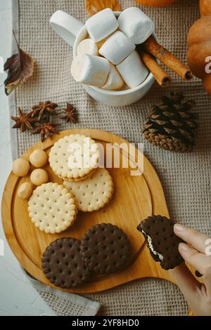Genießen Sie Winterspezialitäten wie Marshmallows, Kekse und Schokoladen-Sandwiches in einer gemütlichen Umgebung Stockfoto