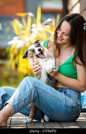 Entzückendes australisches Schäferhündchen mit glücklicher Frau. Ein Bündel von Flaute und Liebe, bereit, dein Herz zu stehlen Stockfoto