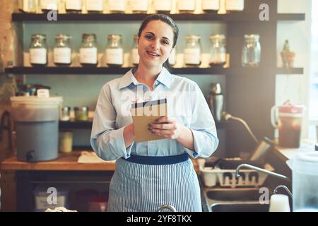 Barista, glücklich und Porträt mit Notebook im Restaurant mit Vertrauen für das Gastgewerbe. Job, Schriftstellerin und Kellnerin in Kanada Stockfoto