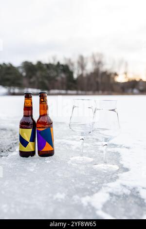 Bierflaschen und Gläser im Schnee Stockfoto