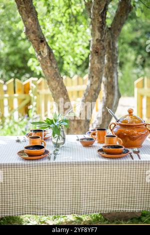 Ein Tisch mit wunderschönem Steingut im Hof an einem sonnigen Sommertag Stockfoto