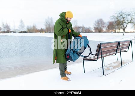 Junger Mann bereitet sich auf ein kaltes Winterschwimmen vor, einen gesunden Lebensstil. Stockfoto