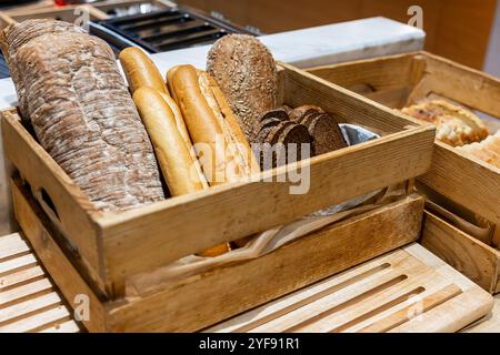 Auswahl an frischem Brot in rustikalen Holzkisten am Buffet Stockfoto