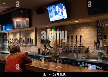 Ein Schirmherr in einer Bar in Chicago, Illinois, sieht, wie die Ergebnisse der US-Präsidentschaftswahlen 2016 im Fernsehen bekannt gegeben werden. Stockfoto