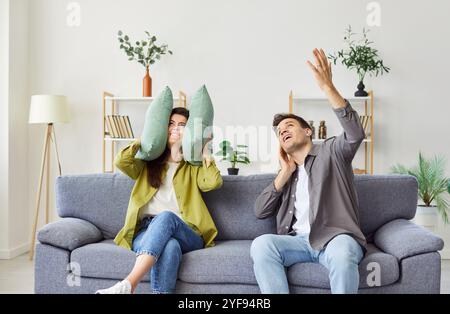 Ein junges, irritiertes Ehepaar leidet oben unter lauten Nachbarn. Stockfoto