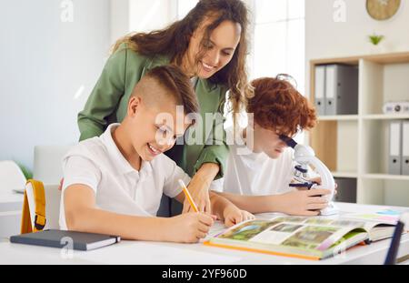 Lehrerin beugt sich über Schüler in der Klasse, Nahaufnahme Stockfoto