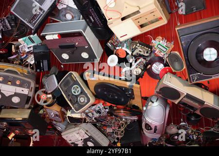 Venedig, Italien - 7. Mai 2024: Ausländer überall 60. Venedig Kunstbiennale. John Akomfrah, hört die ganze Nacht den Regen im British Pavilion. Alte Video- und Audio-Player hängen von der Decke des roten Zimmers. Stockfoto