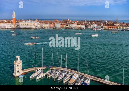 Stadt Venedig und Lagune von Venedig in Italien. Blick von oben mit der Skyline der Stadt und Segelbooten in der Marina der Insel San Giorgio Maggiore mit Leuchtturm. Stockfoto