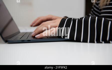 Nahaufnahme von weiblichen Händen, die auf der Laptop-Tastatur tippen, einer Frau, die arbeitet oder studiert Stockfoto