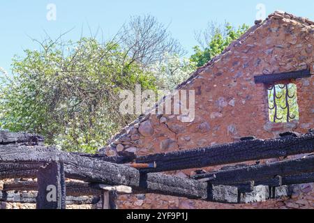 Ein verbranntes Gebäude mit verbleibenden Steinmauern Stockfoto