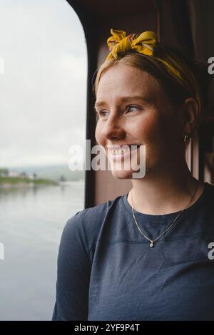 Nahaufnahme einer nachdenklichen jungen Frau am Fenster in der Fähre Stockfoto