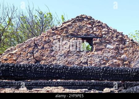 Ein verbranntes Gebäude mit verbleibenden Steinmauern Stockfoto