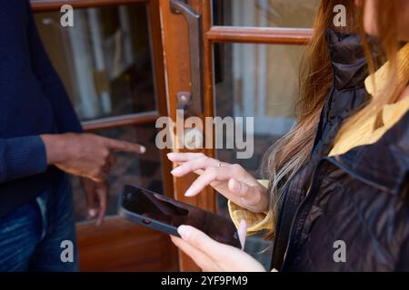 Hochwinkelmitte einer Inspektorin mit Smartphone Stockfoto